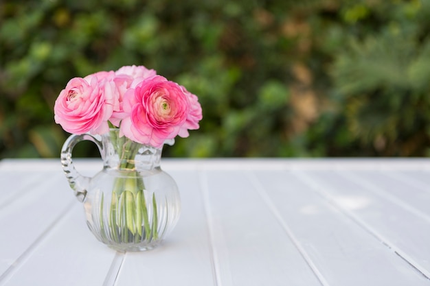 Free photo glass vase with flowers in pink tones