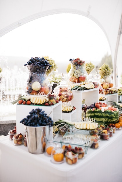 Free Photo glass vase with grape stand on dinner table with fruits