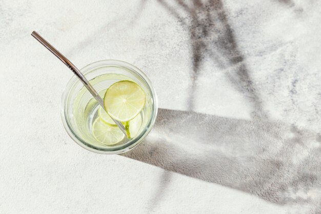 Glass of water with lemon slices on table