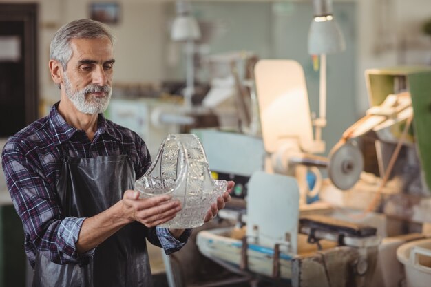 Glassblower examining glassware