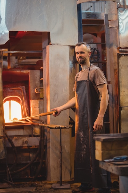 Glassblower heating a glass in glassblowers oven