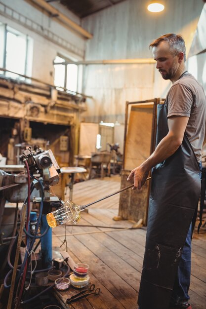 Glassblower shaping a molten glass