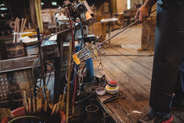 Glassblower shaping a molten glass