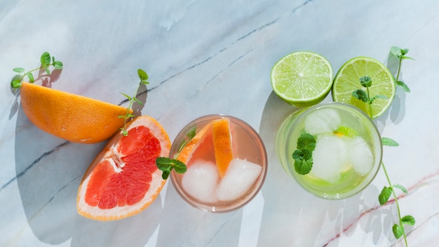 Glasses of citrus drink with sliced fruit