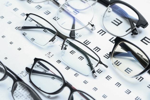 Glasses and eye chart on white background