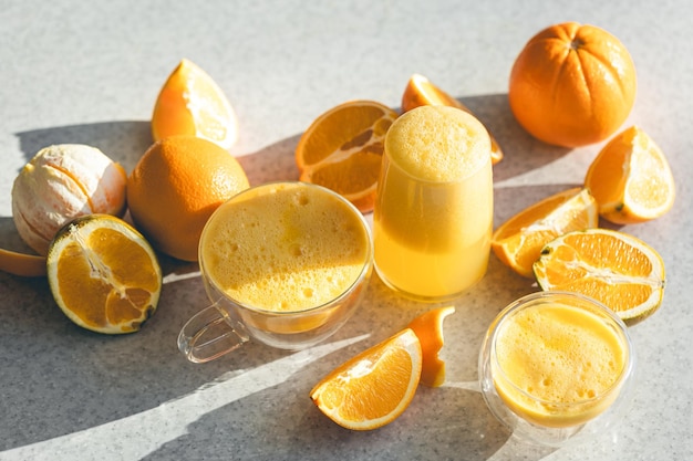 Glasses of freshly squeezed orange juice and fruit oranges on the kitchen table