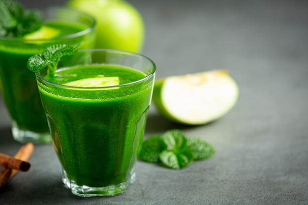 Glasses of green apple healthy smoothie put next to fresh green apples