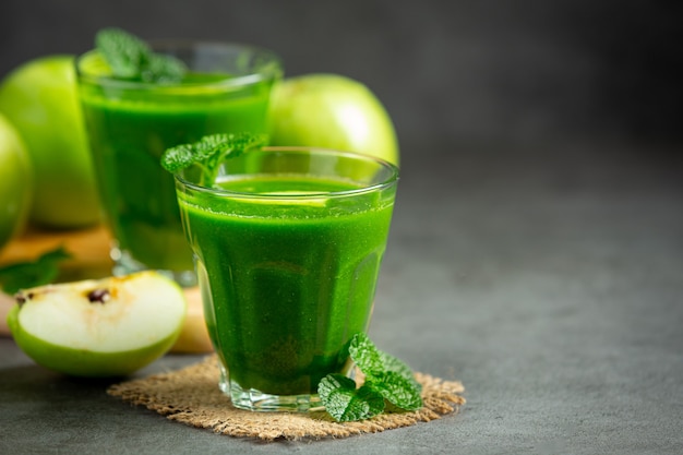 Glasses of green apple healthy smoothie put next to fresh green apples