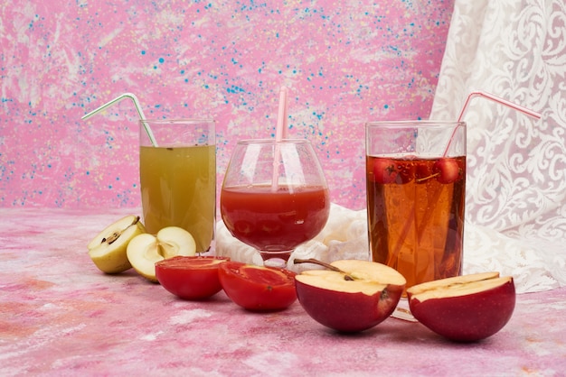 Glasses of juice with apple and tomato.