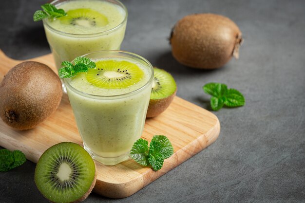 Glasses of kiwi juice put on wooden cutting board