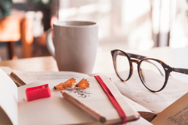 Free photo glasses and mug near notebook and books