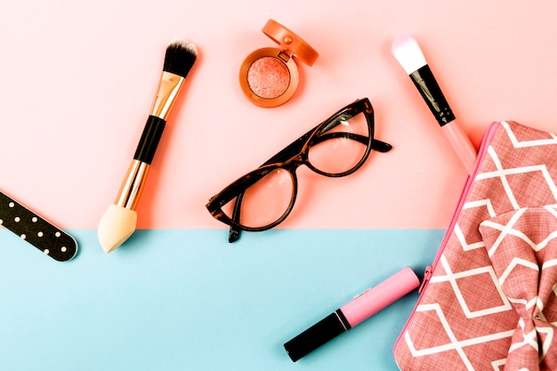 Glasses near makeup bagf and cosmetics