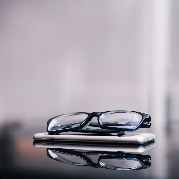 Free Photo glasses and phone on table