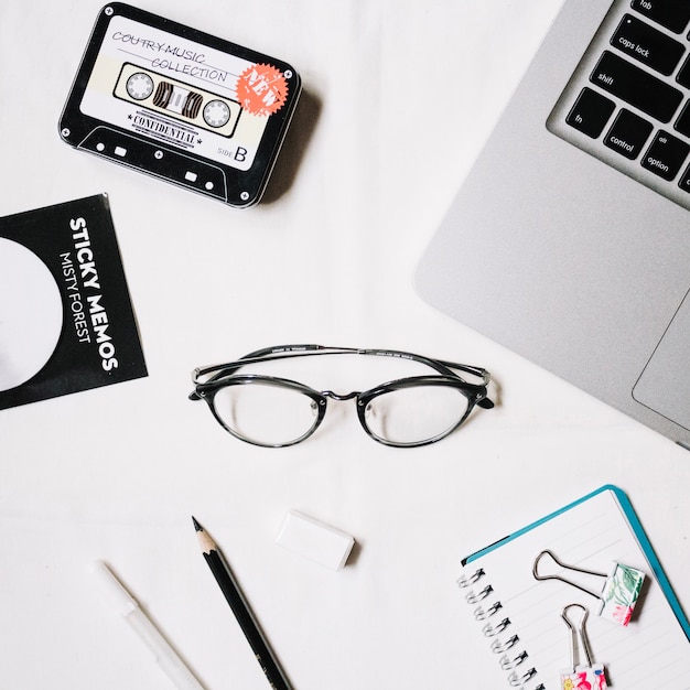 Glasses and stationery near laptop