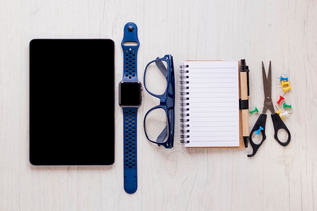 Free photo glasses and watch amidst office supplies