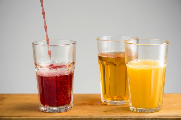 Free photo glasses with apple, orange and cherry juice