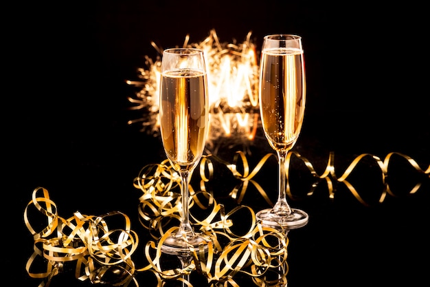 Glasses with champagne against holiday lights