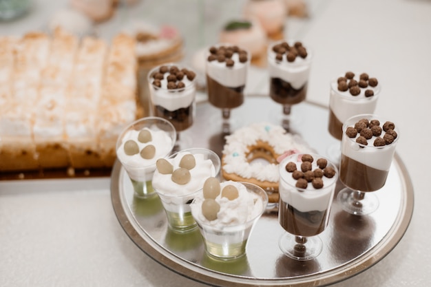 Free photo glasses with portion of cream desserts stand on catering table