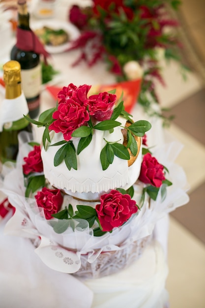 Glaze roses and leaves decorate wedding bread enveloped in white