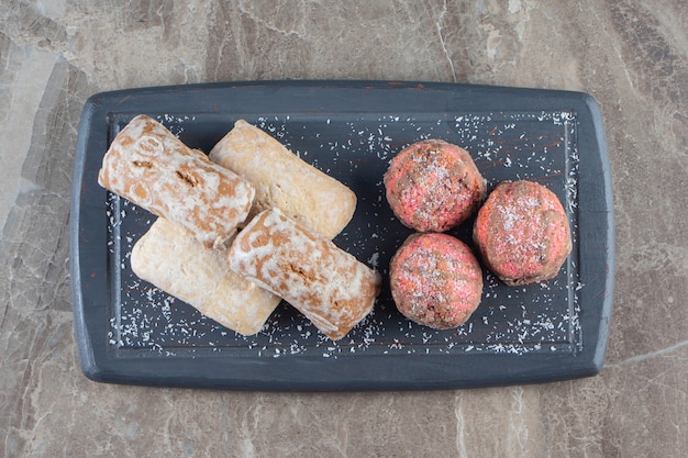 Glazed cookies and gingerbreads on a tray on marble.