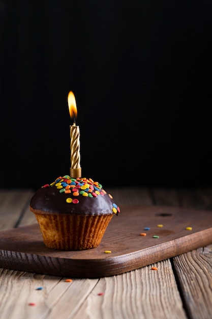 Free photo glazed cupcake with lit candle