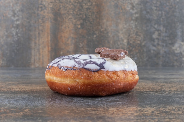 Free Photo glazed donut and a pine branch on marble surface