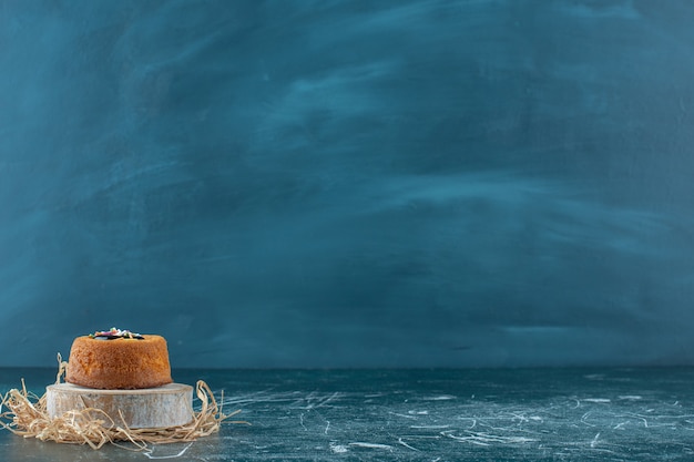 Free photo glazed mini cake on a board, on the blue background. high quality photo