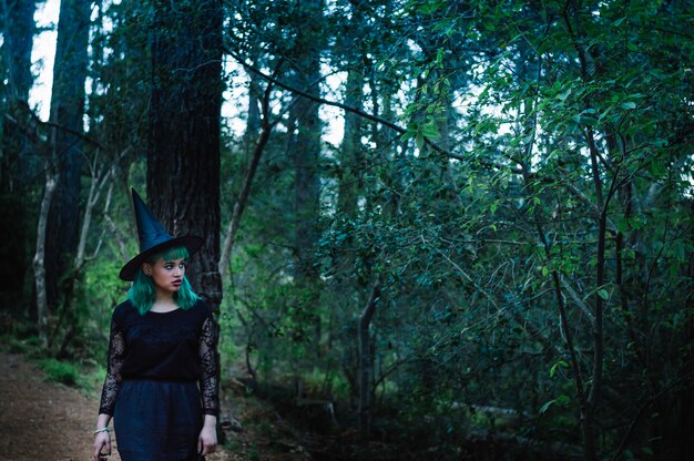 Gloomy witch in dark forest