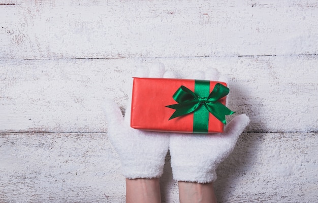 Gloved hands holding a red gift