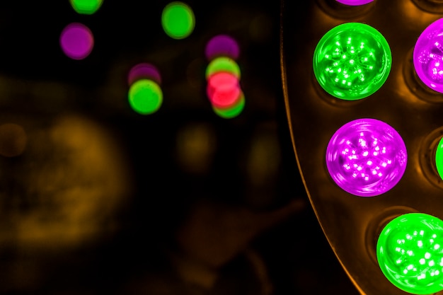 Glowing green and pink led bulb on background