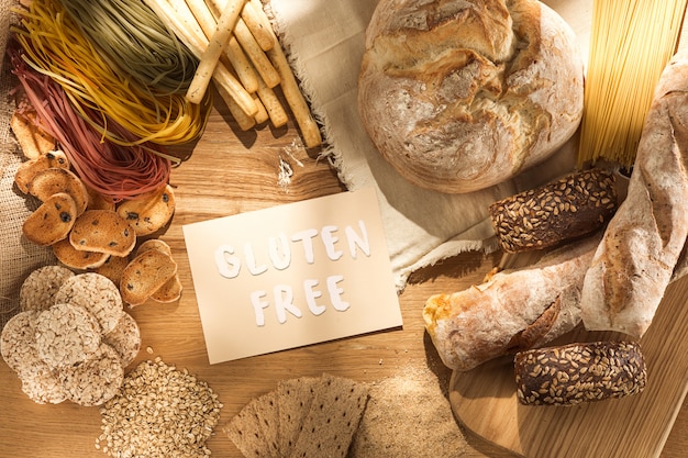 Gluten free food. Various pasta, bread and snacks on wooden background from top view