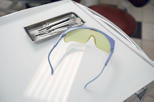 Free photo goggles in the dentist's office.the tools lie on a tray.preparing the dentist before admission