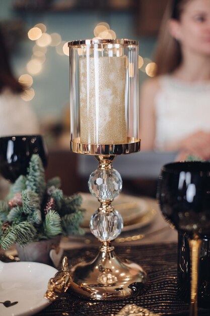 Gold candlestick standing on the festive table at home. New Year eve concept