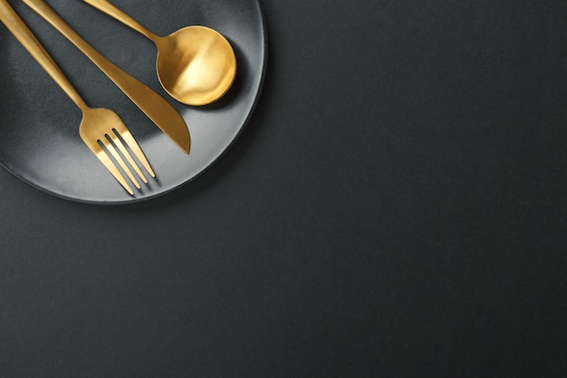 Free Photo gold cutlery set on black background