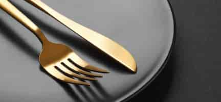 Free photo gold cutlery set on black background