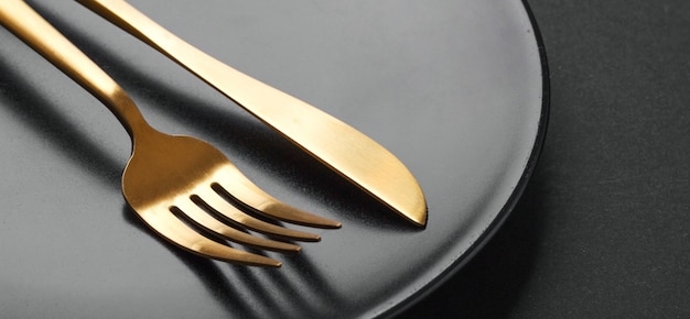 Free Photo gold cutlery set on black background