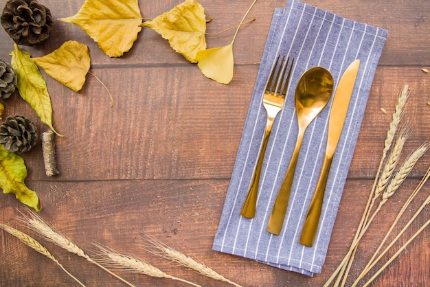 Free Photo gold cutlery set on napkin with leaflets