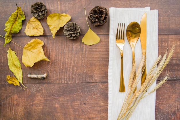 Gold cutlery set on napkin with wheat 