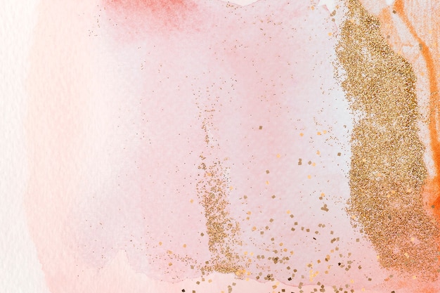 Free photo gold glitter on pink watercolor background