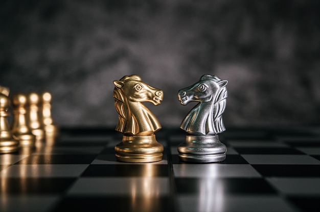 Free photo gold and silver chess on chess board game for business metaphor leadership concept