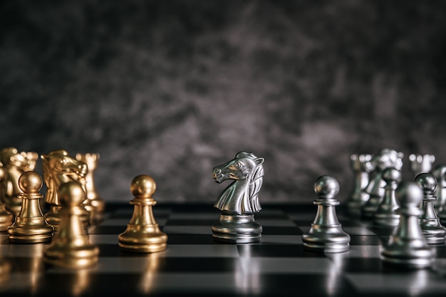 Free photo gold and silver chess on chess board game for business metaphor leadership concept