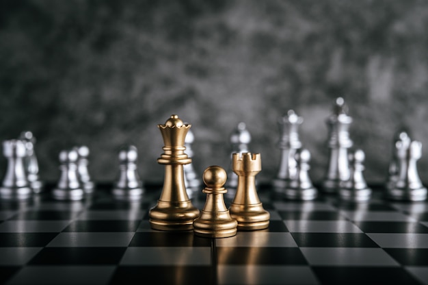 Gold and Silver Chess on chess board game for business metaphor leadership concept