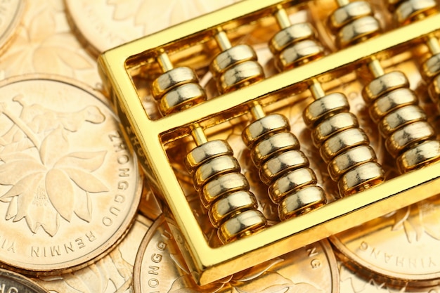 Free photo golden abacus with chinese rmb gold coins as background