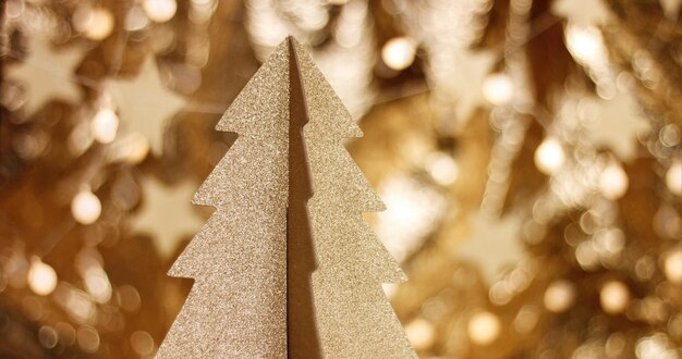 Free photo golden cardboard cristmas tree close up with sparkling stars and lens flare in warm gold tones loop