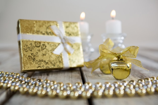 Free photo golden christmas decoration on a wooden table with a gift