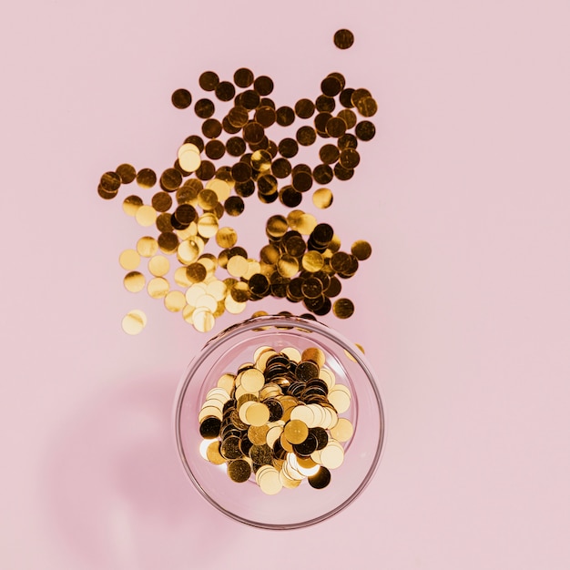 Free photo golden confetti in transparent glass at party