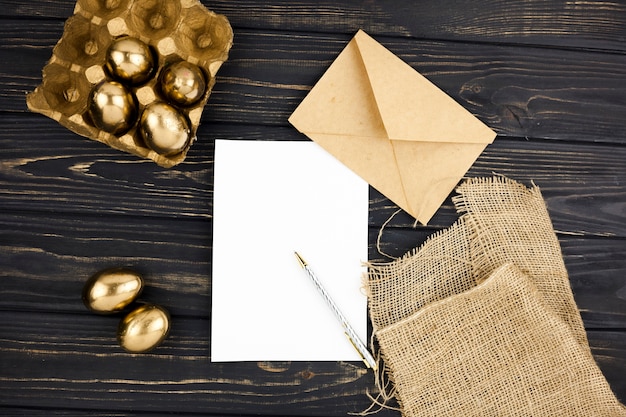 Free photo golden eggs near paper and envelope