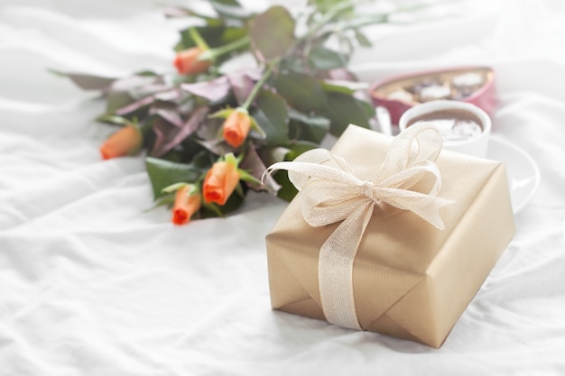 Golden gift with a golden bow and flowers