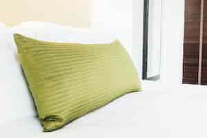 Free photo golden pillow on the bed with white sheets