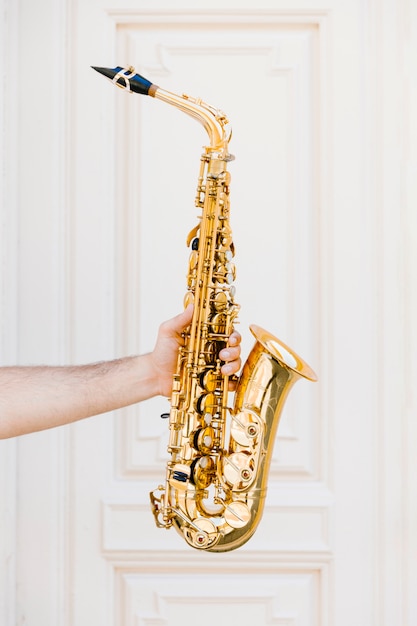 Free Photo golden saxophone held by person